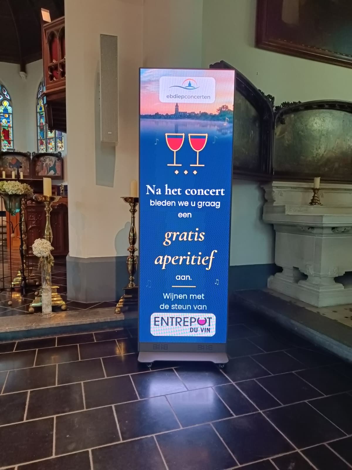LED-wand in de kerk voor het aperitief met wijnen van Entrepot du Vin na het concert van 18 oktober 2026